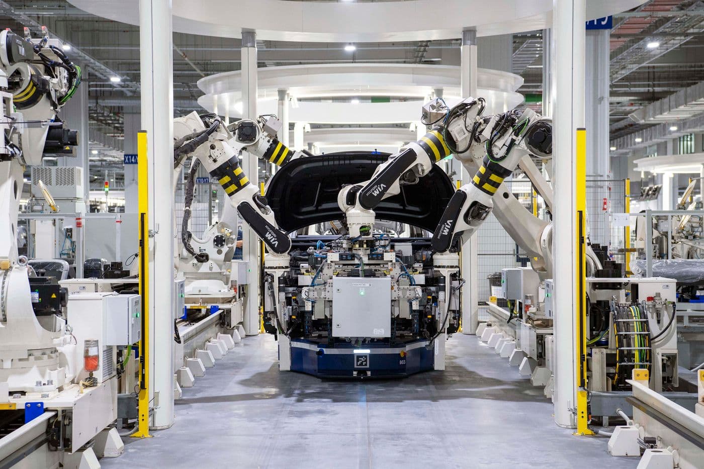 Robotic arms assembling a vehicle body on a bright production line