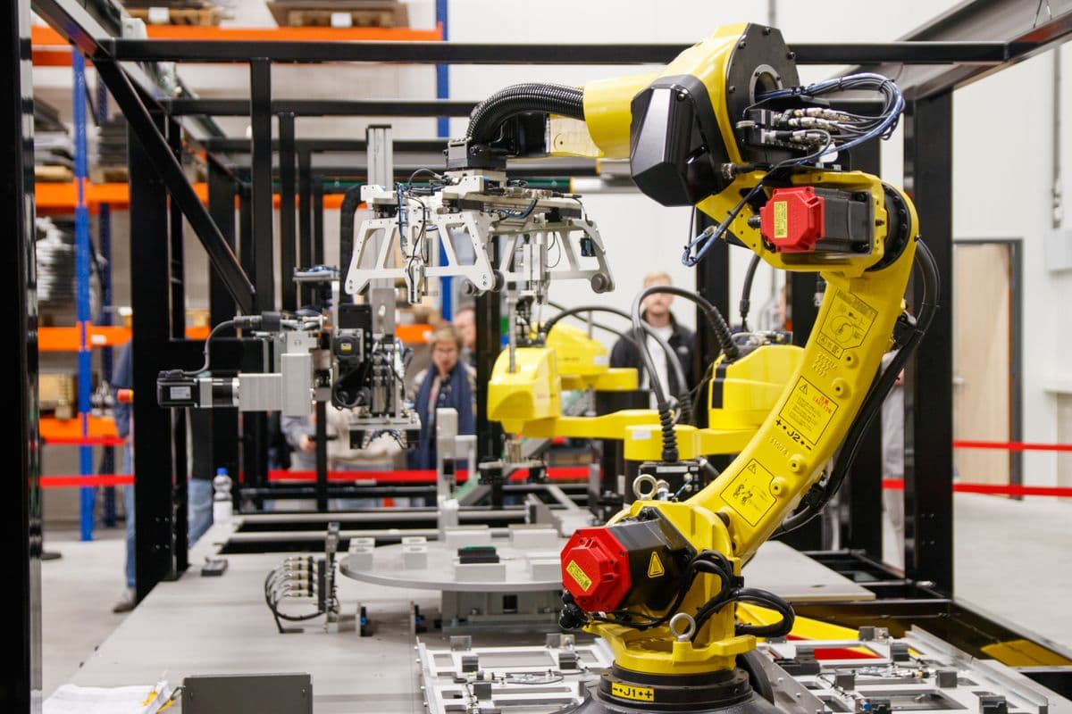 Orange industrial robotic arm on a manufacturing production line